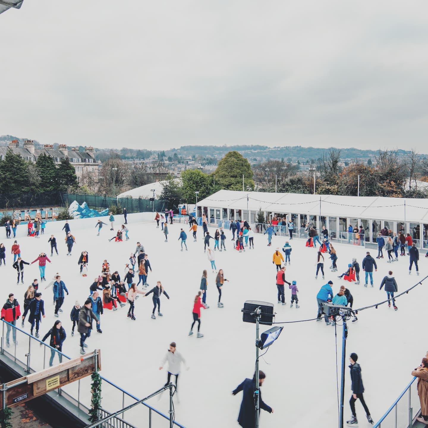 Lots of ice skaters enjoying the festive winter ice rink in Bath. 